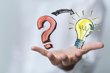 Hand auf der man ein Fragezeichen und eine Glühbirne sieht