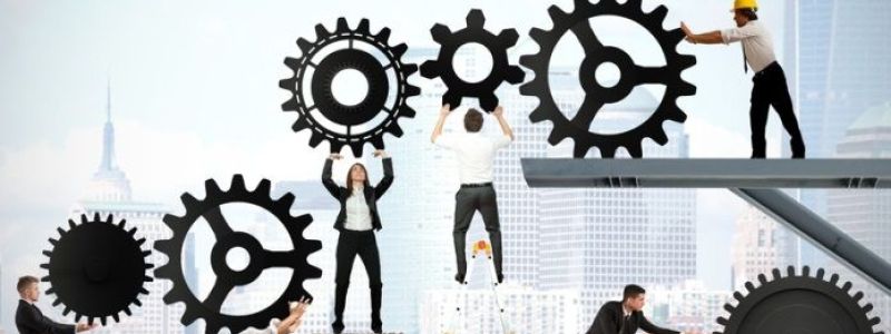 Menschen die verschiedene Zahnräder bedienen