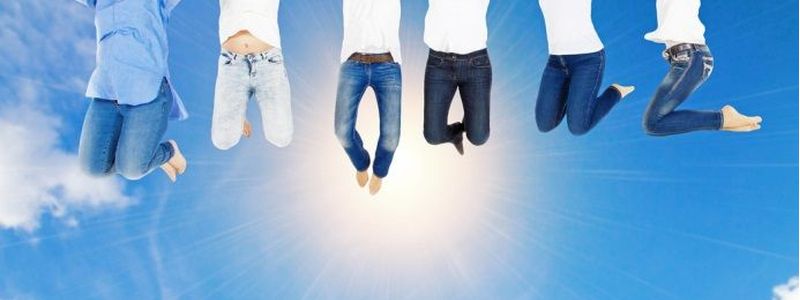 Der Himmel mit Sonne sowie sechs Menschen deren untere Körperhälfte man sieht, da sie hoch springen